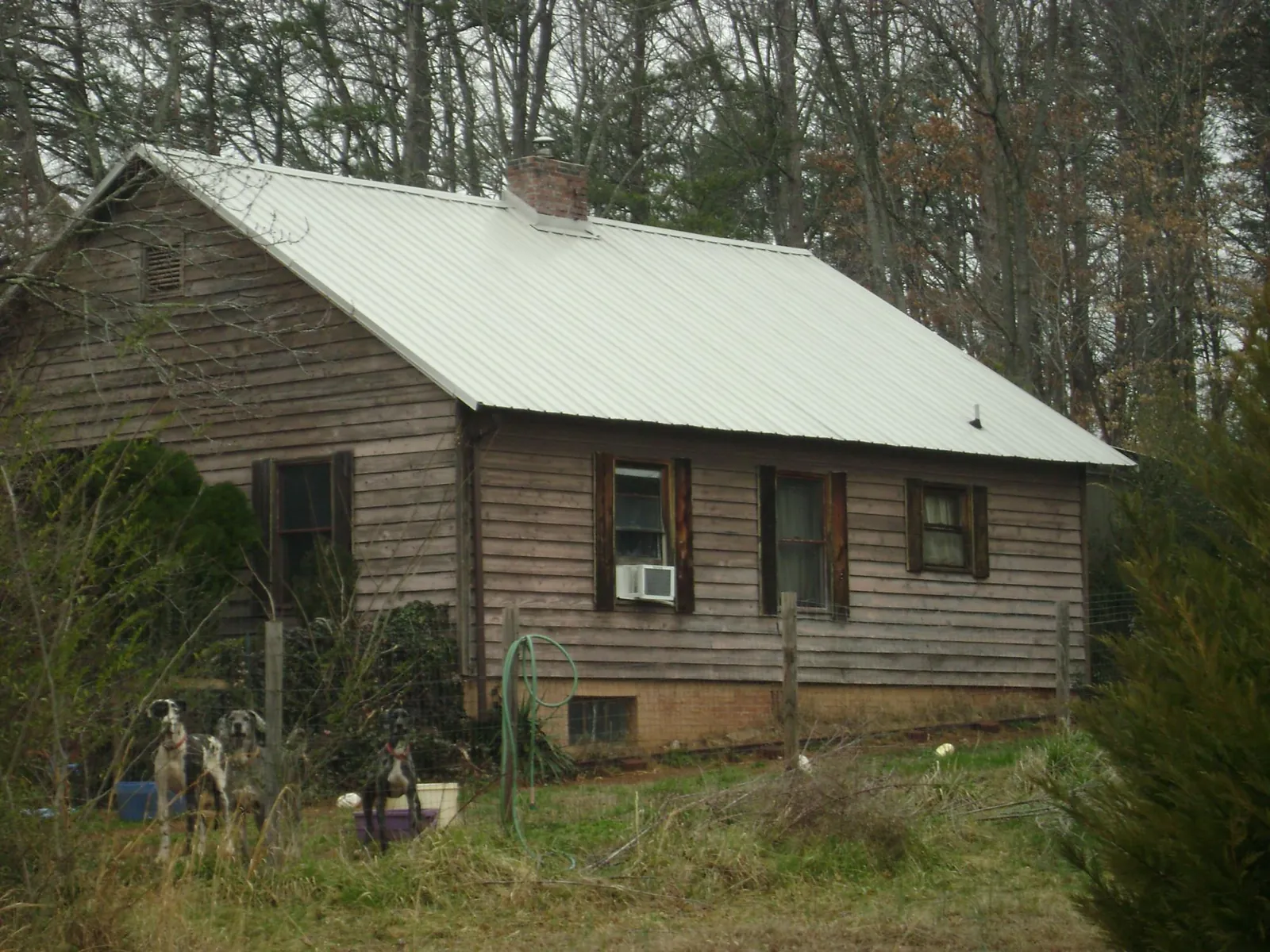 White metal roof on an old wood sided farmhouse, from a Asphalt Shingle Roof Repair job in Waco